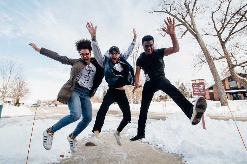 Three happy people jumping