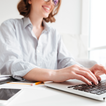 Happy woman typing on a notebook